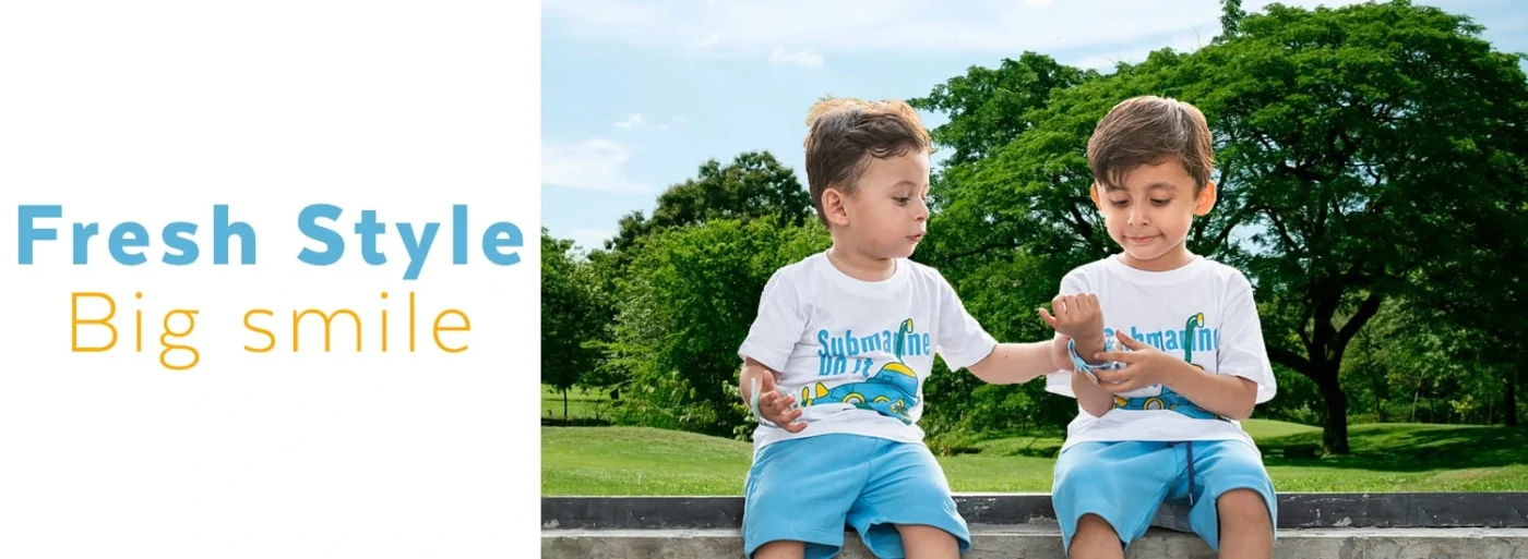 Two boys wearing matching Starwears submarine-print t-shirts and blue shorts outdoors